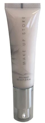 En vit tub med silverlock märkt 'MAKE UP STORE' och 'skin repair'. Det är en hudvårdsprodukt.