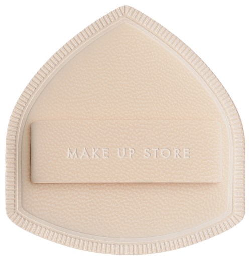 A beige triangular makeup sponge with a brand name of MAKE UP STORE on a band. The sponge has a textured surface.
