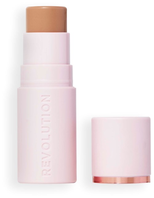 A beige makeup stick in a pink container with a removable cap. The word 'REVOLUTION' is written on the container.