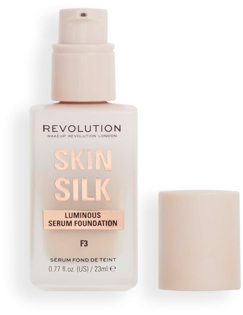 Een witte fles Revolution Skin Silk foundation met pomp en losse dop ernaast.