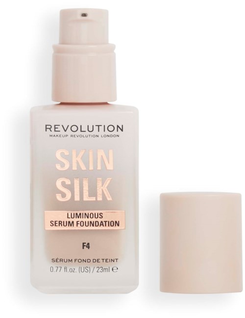 A white bottle of REVOLUTION Skin Silk Luminous Serum Foundation with a cap beside it.