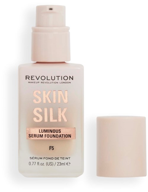 A bottle of Revolution Skin Silk foundation with a pump and an attached cap.