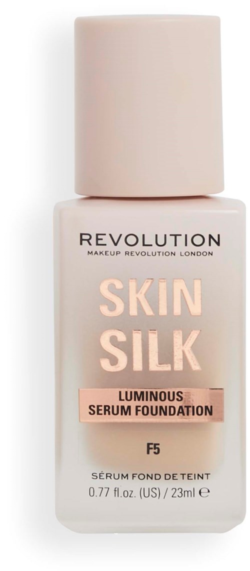 A bottle of foundation called Skin Silk by Revolution, with soft pink and beige colors, labeled as luminous serum.