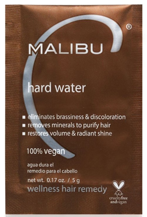 Bruine verpakking met 'Malibu hard water' die beweert roestharstoelen te verwijderen, mineralen te zuiveren, glans te herstellen en vegan te zijn.
