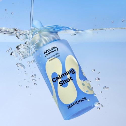 Een blik van Mamonde Calming Shot verzorgingsproduct spat in het water. Het heeft blauwe en witte kleuren en tekst.