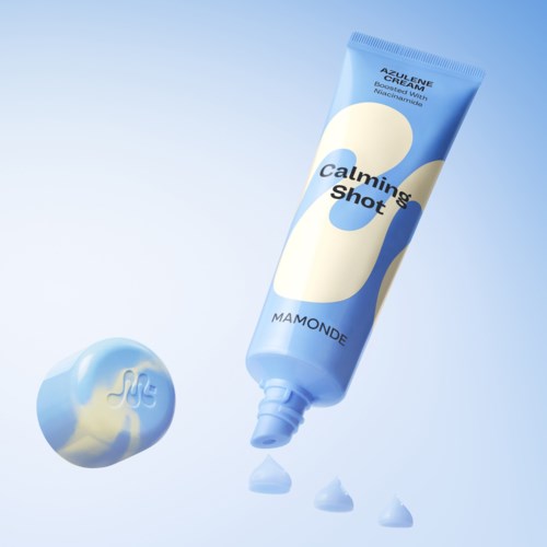 Een tube kalmerende crème verbonden met een toefje crème en druppels, met zachte blauwe achtergrond.