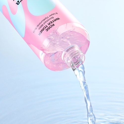 Een roze doorzichtige fles met 'WATER OF LIFE' op het label giet heldere vloeistof in water.
