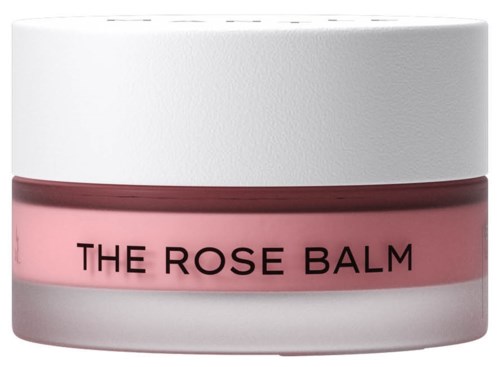 Een pot met witte deksel en roze body, gelabeld 'The Rose Balm', waarschijnlijk een huidverzorgingsproduct.