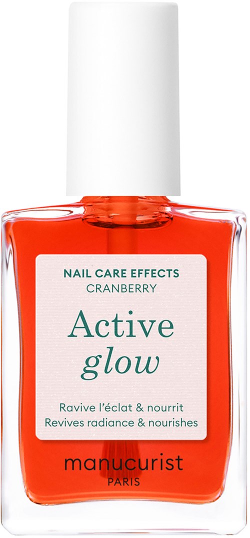 A bottle of nail care nail polish with a white cap, orange color, and label that says 'Active glow' and 'manucurist Paris.'