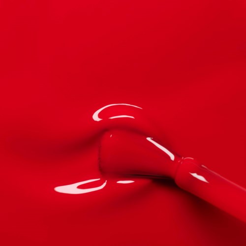 A red lipstick is being applied, blending with a red background for a bold look.