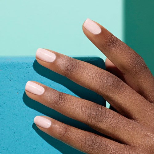 A hand with neatly manicured nails against a colorful background. The fingers are slender and well-groomed.