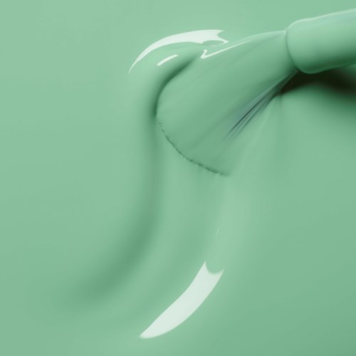A brush applies light green paint on a surface.