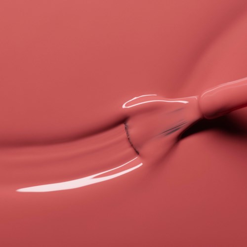 A pink lip gloss tube is squeezing out shiny gloss onto lips.