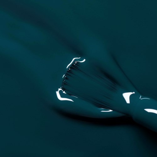 A close-up of fabric being pulled, creating ripples and shadows in dark teal color.