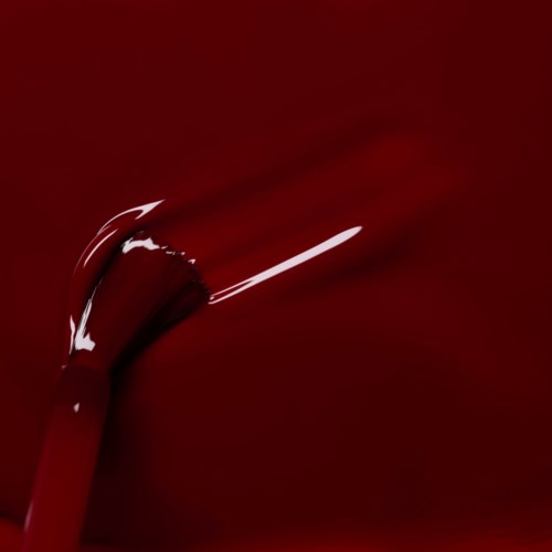 A paintbrush painting on a red background. The brush is curved and has white paint on it.