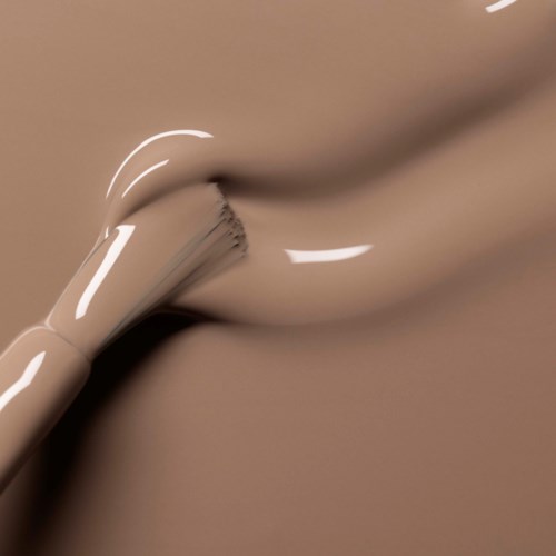 A close-up of smooth, beige-colored silicone with shiny highlights, showing its flexible, knot-like shape.