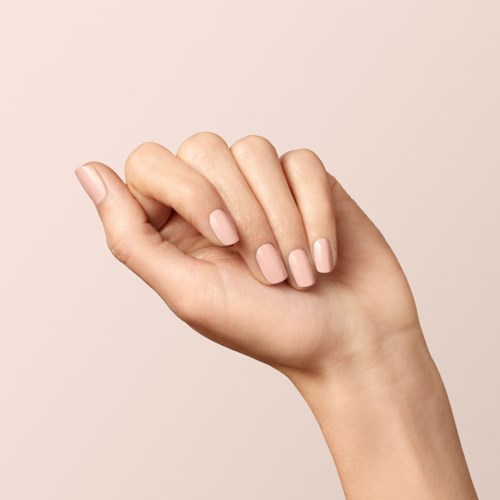 A hand with painted nails making a fist, against a plain light background.