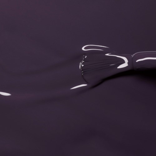 A dark fabric with a shiny, curved, metallic object or ribbon on top, creating reflections and smooth folds.