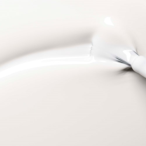 A white brush or applicator is spreading white paint or cream on a white surface.