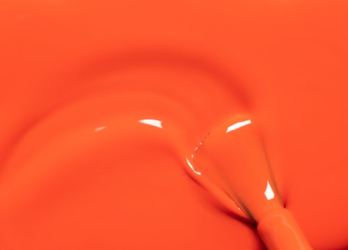 En närbild av en mekanisk apparat med ett ljusrött handtag. Det verkar vara för att skära eller klämma.