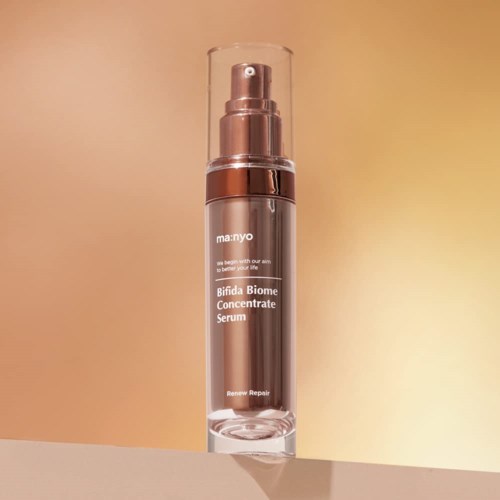 Een huidverzorgingsfles met label "Bifida Biome Concentrate Serum" met pomp en doorzichtige dop, staat op een oppervlak.