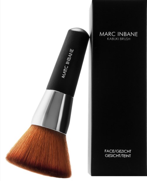 A makeup brush with a black handle, silver band, and brown bristles, next to a black box with white text.