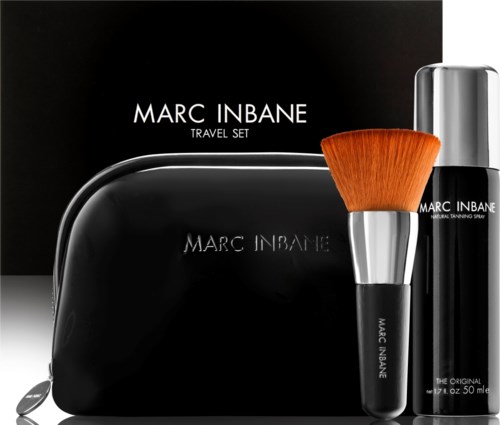 A Marc Inbane travel set with a black bag, botle, and makeup brush. The items are stylish and well-arranged.