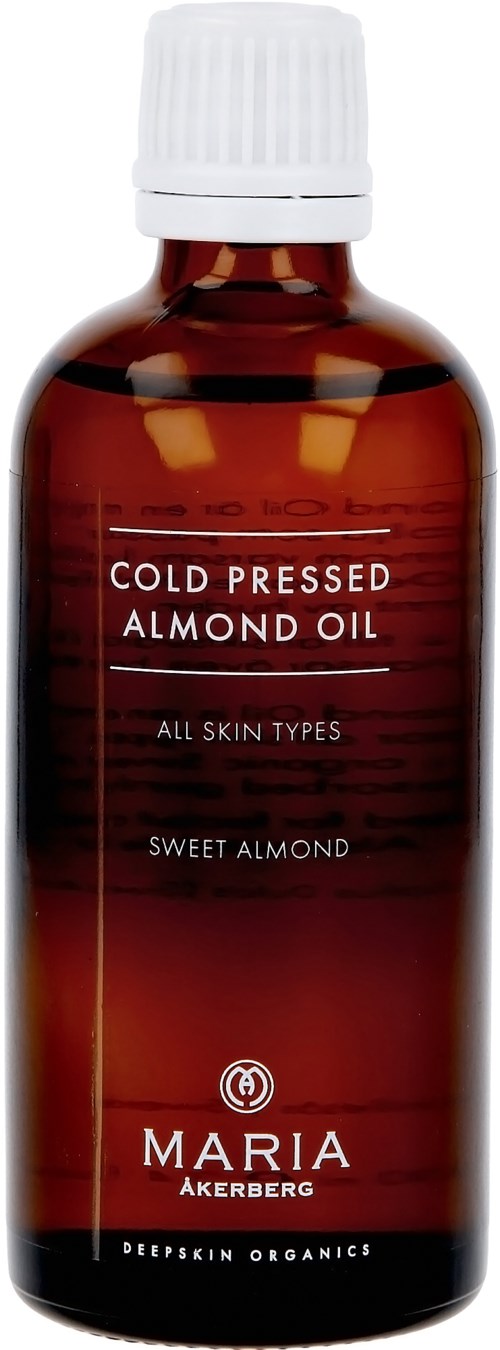 Dunkelbraune Flasche mit weißem Deckel, bezeichnet 'Cold Pressed Almond Oil', geeignet für alle Hauttypen, von Maria Akereg.