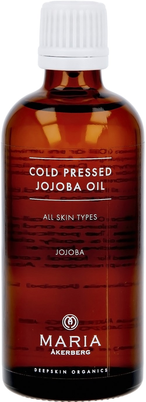 A small brown bottle of cold pressed jojoba oil with a white cap, labeled for all skin types.