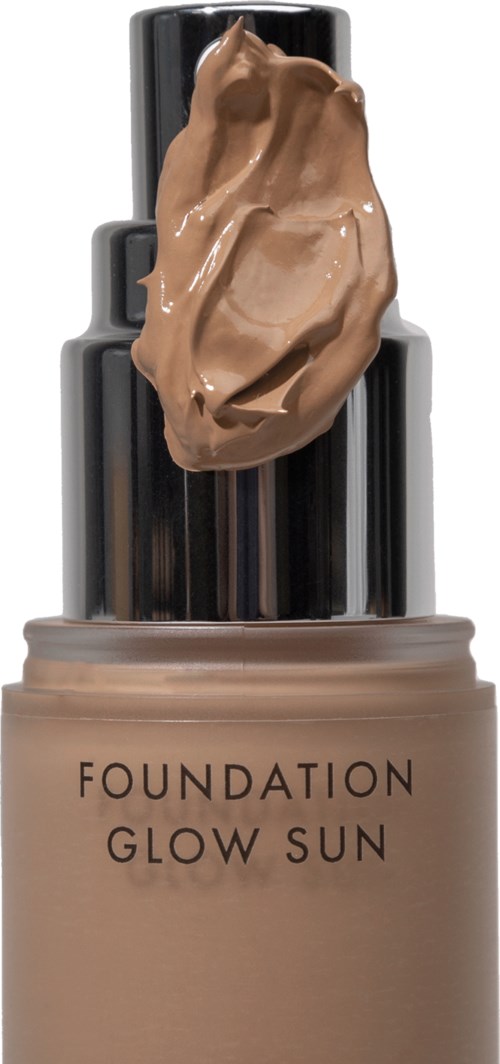 Eine Foundationflasche mit einem Klecks Make-up oben und einem glänzenden schwarzen Verschluss.