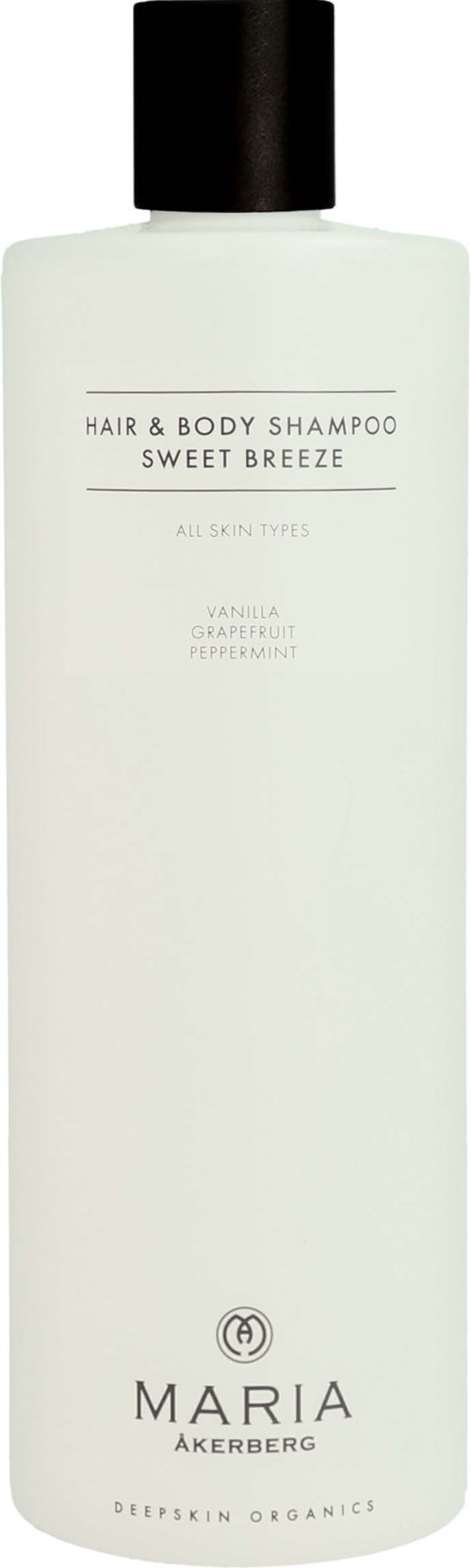 Een lange, witte fles met een zwarte dop, met label 'Hair & Body Shampoo Sweet Breeze' met vanille- en grapefruitgeur.