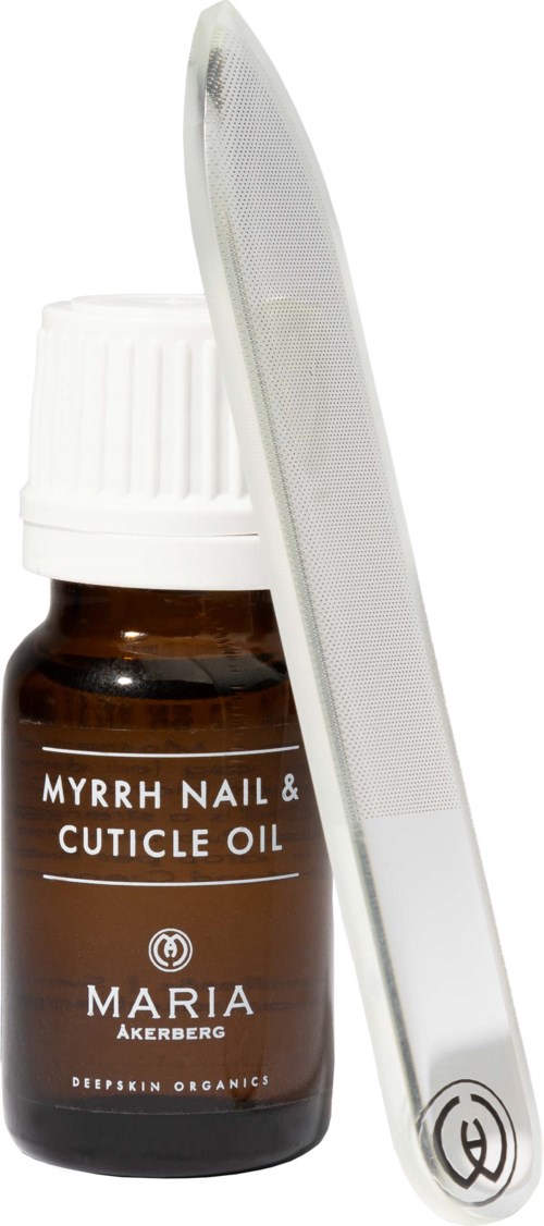 A small brown bottle labeled 'Myrrh Nail & Cuticle Oil' with a white nail file leaning against it.