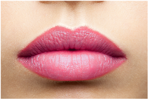 Close-up of full, pink lips with detailed texture and smooth skin surrounding.