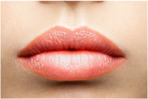 Close-up of full, pink lips with smooth skin around them.
