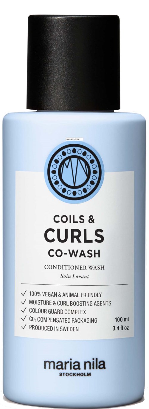 Een lichtblauwe fles met zwarte dop, gelabeld 'Coils & Curls Co-Wash' door Maria Nila, uit Stockholm.