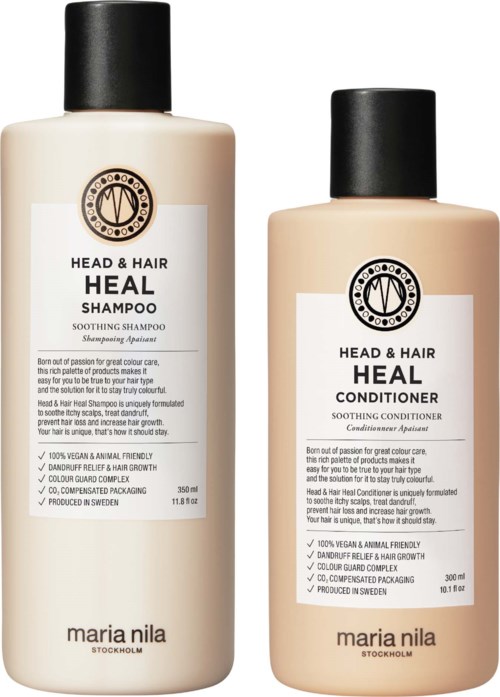 Two bottles of Heal shampoo and conditioner with black caps and white labels sit side by side.