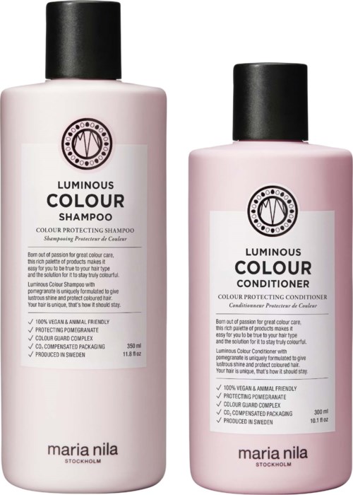 Zwei pinke Haarpflegeflaschen mit den Labels 'Luminous Colour Shampoo' und 'Luminous Colour Conditioner' von Maria Nila. Sie stehen aufrecht.