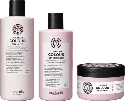 Three hair care products: shampoo, conditioner, and hair mask, all in pink containers with black lids from Maria Nila.