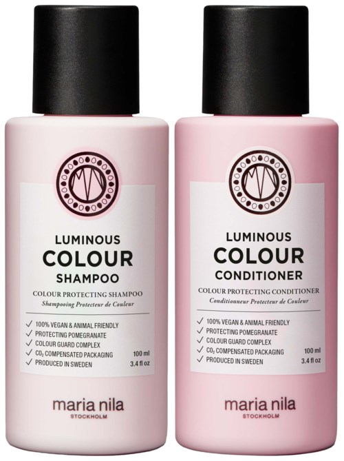 Two pink bottles, one for shampoo and one for conditioner, with black caps and white labels. They are from Maria Nila.