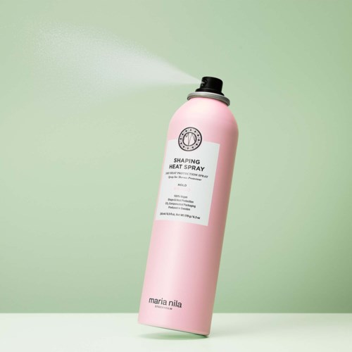 A pink can of shaping heat spray with a black nozzle on a green background.