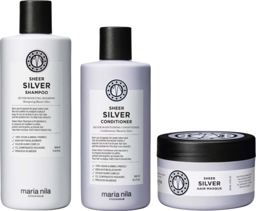 En serie hårvårdsprodukter: silver schampo, balsam och hårmask i vita behållare med svarta lock.