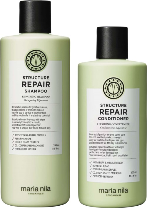 Two bottles of hair care products, one for repairing shampoo and one for repairing conditioner, both with green labels and black caps.
