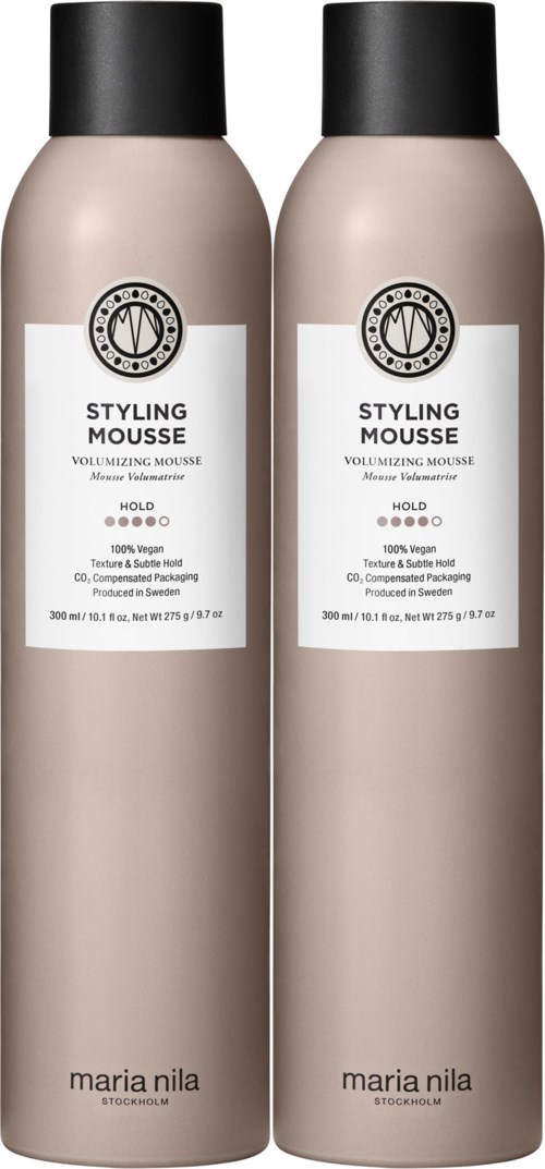 Two beige bottles of styling mousse with black caps and white labels sit side by side.
