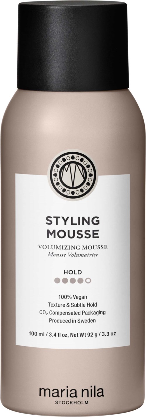 A beige and black bottle of styling mousse labeled "Volumizing Mousse" by Maria Nila.