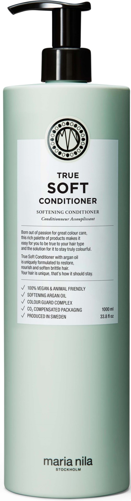 Een lange, groene fles met een zwarte pomp, gelabeld True Soft Conditioner door Maria Nila, heeft een witte label met zwarte tekst.