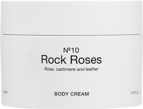 Ett vitt förpackning av kroppskräm märkt nummer 10 Rock Roses med doft av ros, cashmere och läder.
