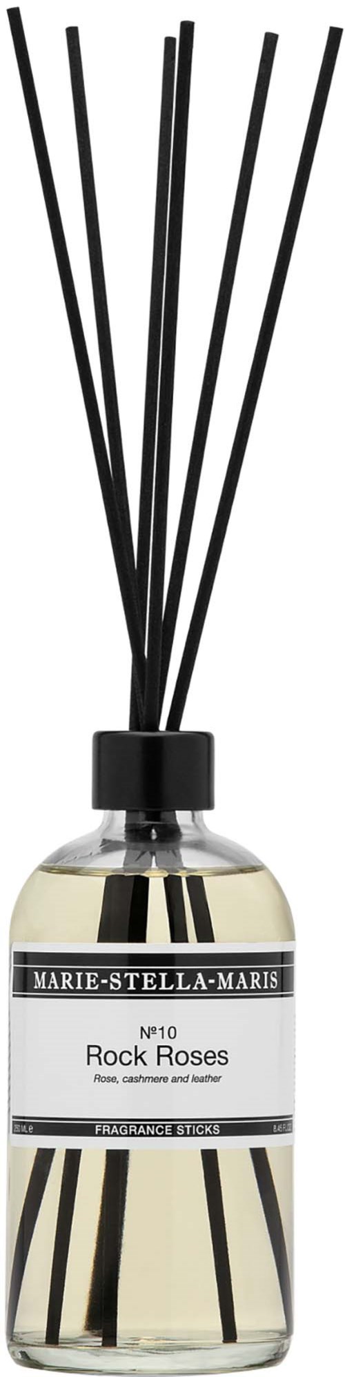 Een fles met zwarte stokjes erin, met label Marie-Stella-Maris Rock Roses, bevat geur met een strak design.
