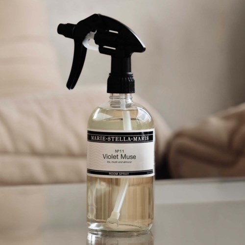 Een doorzichtige sprayfles met een zwarte nozzle bevat een kamer spray met het label Marie-Stella-Maris Violet Muse.