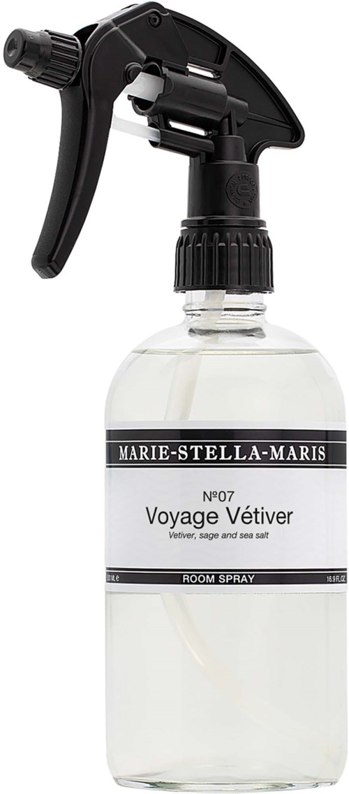 Een sprayfles met een zwarte spray en een wit label met de titel Voyage Vétiver.