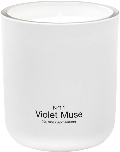 En vit doftljusbehållare märkt Violet Muse med doftnoter av iris, mysk och mandel.